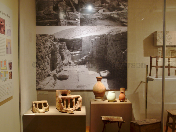 Ancient Model Houses In Front of A Picture of House Ruins from a Similar Era